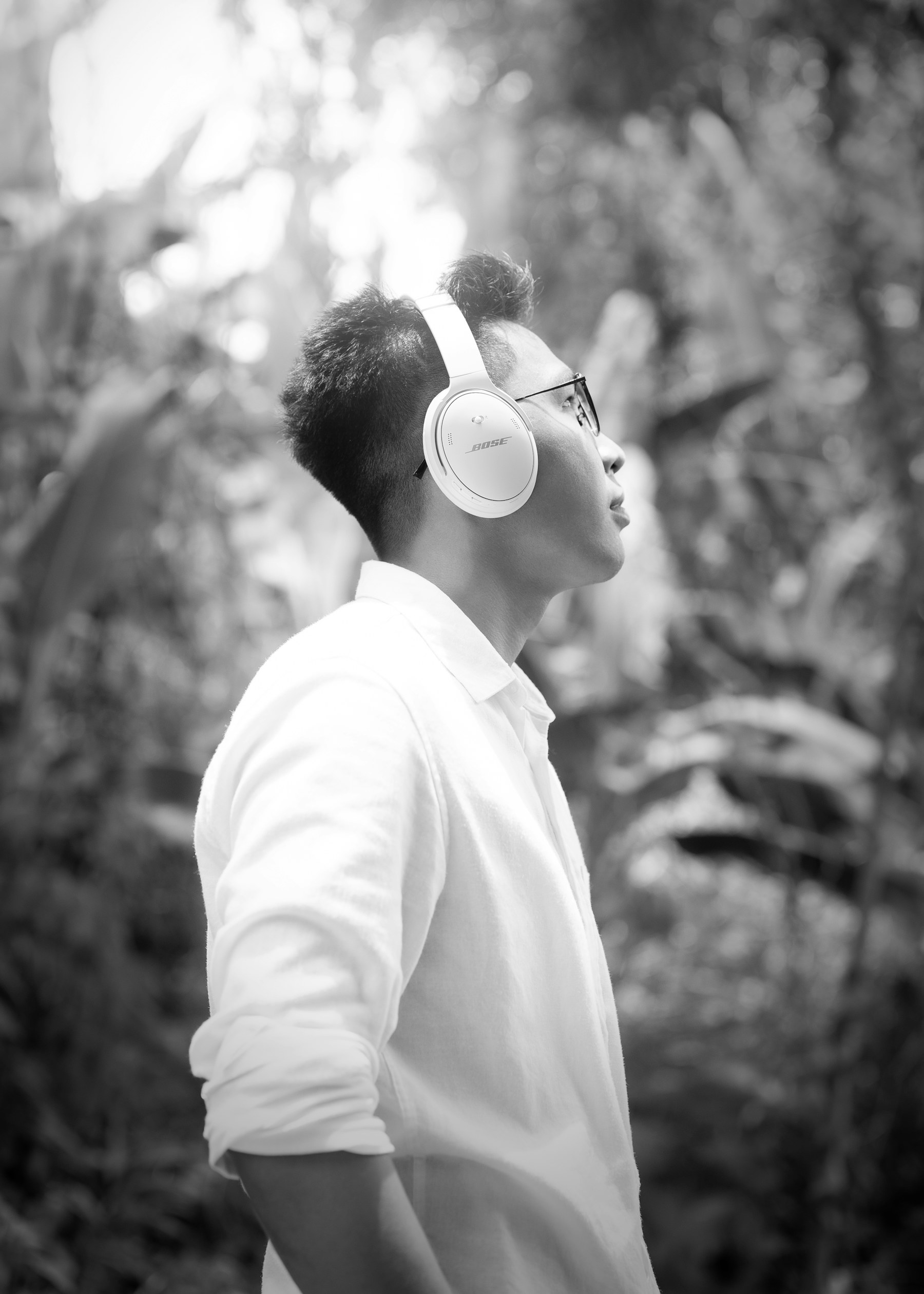 Person wearing headphones in a forest, immersed in a natural sound environment.